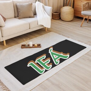 May include: A black yoga mat with the name "LEA" written in green and brown letters.