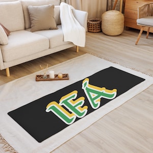 May include: A black yoga mat with the name "LEA" written in green and yellow letters.
