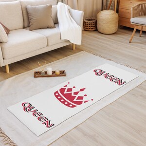 May include: White yoga mat with a red crown and the word "Queen" printed in black on each end.