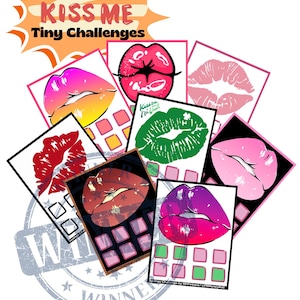 May include: A set of colourful lip-shaped cards with a grid of squares on each card. The cards are arranged in a pile with a large, grey, distressed stamp that says "Winner" on top. The cards have the text "Kiss Me Tiny Challenges" on them.