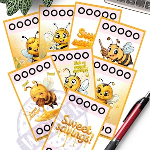 以下が含まれることがあります： 「Sweet Savings!」の文字と漫画のミツバチが描かれたイラストカードのコレクション。貯蓄チャレンジをテーマにしており、進捗状況を追跡するための円があります。ペンと電卓も表示されています。