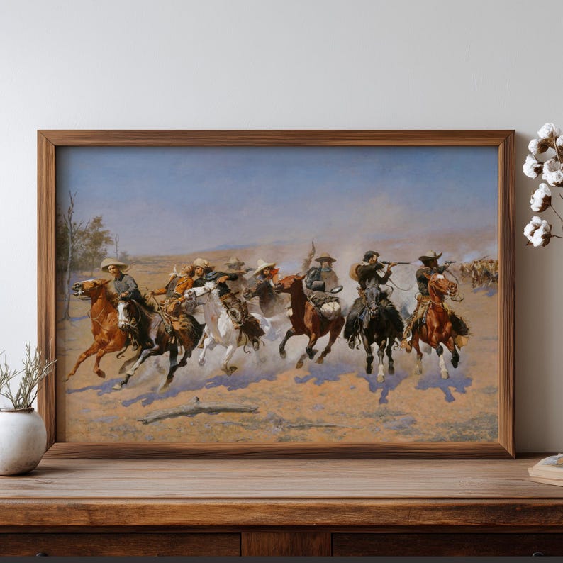 Puede incluir: Una pintura enmarcada de tem&aacute;tica western representa a vaqueros a caballo, persiguiendo ganado a trav&eacute;s de una llanura polvorienta. La obra presenta una composici&oacute;n din&aacute;mica con jinetes con sombreros y chaparreras, sobre un cielo azul y un paisaje marr&oacute;n.