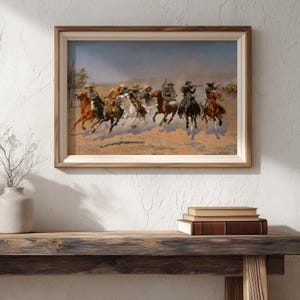 Puede incluir: Una obra de arte enmarcada con tem&aacute;tica del oeste, que representa a vaqueros a caballo en una escena de persecuci&oacute;n din&aacute;mica. La pintura utiliza tonos terrosos, enfatizando el movimiento y la acci&oacute;n. La obra se presenta en un marco de madera.