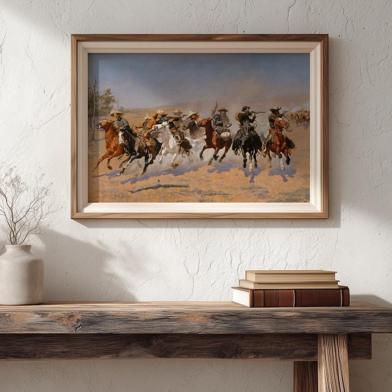 Puede incluir: Una obra de arte enmarcada con tem&aacute;tica del oeste, que representa a vaqueros a caballo en una escena de persecuci&oacute;n din&aacute;mica. La pintura utiliza tonos terrosos, enfatizando el movimiento y la acci&oacute;n. La obra se presenta en un marco de madera.
