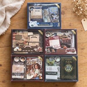 Könnte beinhalten: Fünf rechteckige Schreibwaren-Geschenkboxen mit verschiedenen Themen wie Global Travel, Coffee Bazaar, Weekend Travel, See You Coffee und Butterfly. Jede Box enthält verschiedene Notizblöcke, Aufkleber und dekorative Ephemera.