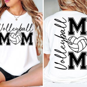 May include: White t-shirt with black text that says "Volleyball Mom" with a volleyball in a heart shape. The back of the shirt has the text "Volleyball" written vertically and the letters "M-O-M" with a volleyball in a heart shape.
