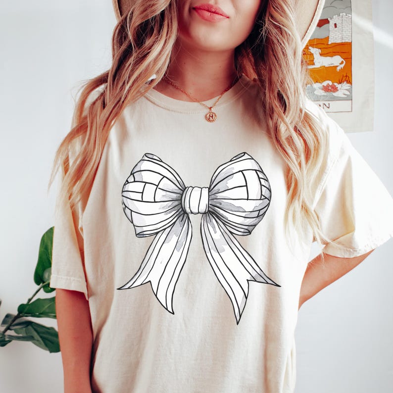 Pu&ograve; includere: T-shirt color crema con un grande disegno a fiocco in scala di grigi. Il fiocco ha un aspetto strutturato, che ricorda un pallone da pallavolo. La maglietta ha maniche corte e una vestibilit&agrave; rilassata, adatta all'abbigliamento casual.