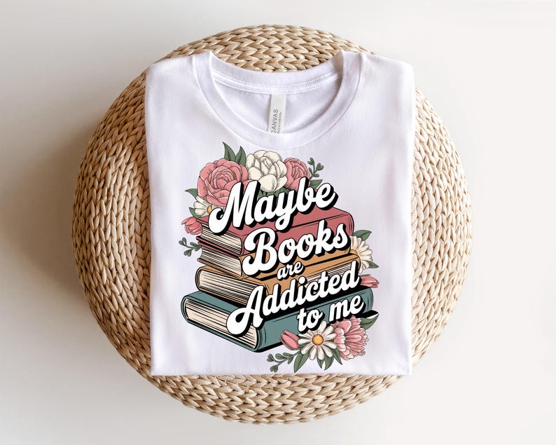 May include: White t-shirt with a floral design and the text "Maybe books are addicted to me".