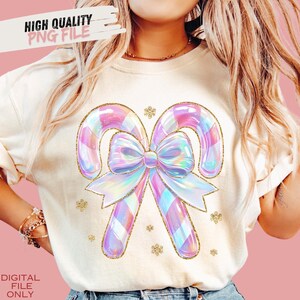 May include: Cream-colored sweatshirt featuring a large, iridescent candy cane design with a bow and gold glitter accents. The text "HIGH QUALITY PNG FILE" is at the top left. The text "DIGITAL FILE ONLY" is at the bottom left.