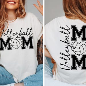 May include: White t-shirt with black text that reads "Volleyball Mom" with a volleyball in a heart shape. The back of the shirt has the text "Volleyball Mom" vertically with a volleyball in a heart shape.