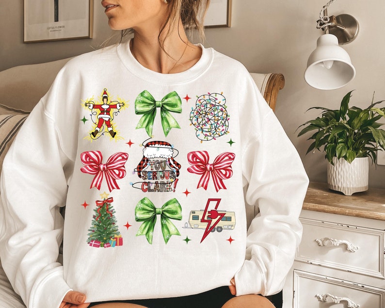 May include: White sweatshirt featuring a festive Christmas design. The design includes images of Christmas lights, bows, a Christmas tree, and the phrase "You Serious Clark!". The sweatshirt is a comfortable, casual style.