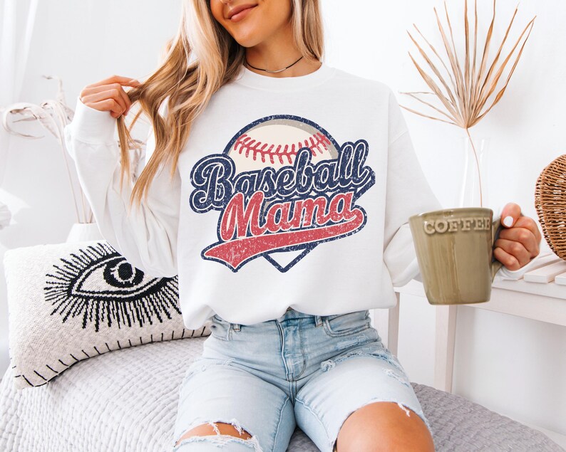 May include: White sweatshirt with a vintage baseball graphic and the text "Baseball Mama".