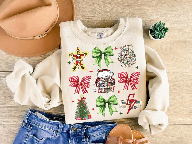 May include: Cream-colored sweatshirt with Christmas-themed graphics. The design includes a Santa Claus figure, green bows, red bows, a Christmas tree, string lights, and the text "YOU SERIOUS CLARE!".