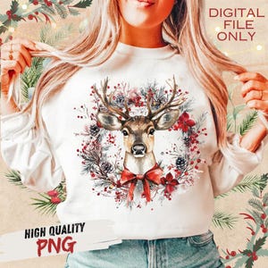 May include: White sweatshirt featuring a deer head with antlers, surrounded by a wreath of red flowers, pinecones, and greenery. A red bow is at the deer's neck. Text on the image reads "DIGITAL FILE ONLY" and "HIGH QUALITY PNG".