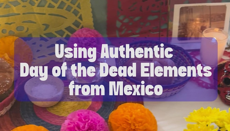 May include: A Day of the Dead altar display featuring yellow and pink paper cutouts, a woven basket, a small bowl of salt, a glass of water, a framed photograph, and a red skull mask, with the text Using Authentic Day of the Dead Elements from Mexico.