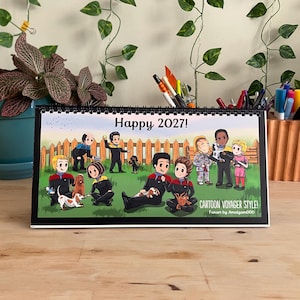 Könnte beinhalten: Ein spiralgebundener Tischkalender mit einer Cartoon-Illustration von Figuren in rot-schwarzen Uniformen mit Hunden auf einer Wiese. Der Text lautet Happy 2027! und Cartoon Voyager Style! Fanart by Amalgam000 in der unteren rechten Ecke.