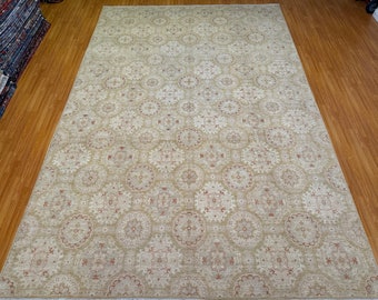 May include: A beige area rug with a repeating pattern of intricate, circular designs in shades of beige and red.