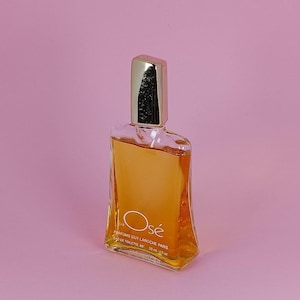 May include: A clear glass bottle of Osé Eau de Toilette by Parfums Guy Laroche Paris. The bottle is 30 ml or 1.0 fl oz. The bottle has a gold cap and a gold label with the name Osé in a circle.