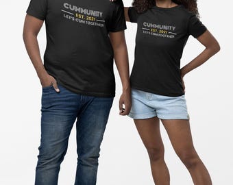 Puede incluir: Dos personas con camisetas negras con el texto "CUMMUNITY EST. 2021 LET'S CUM TOGETHER" en gris. Una persona lleva vaqueros azules y zapatillas negras, la otra pantalones cortos vaqueros y botas color canela.