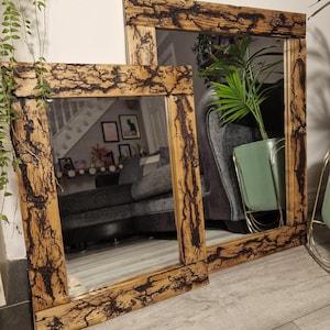 May include: Two rectangular mirrors with thick wooden frames featuring dark, intricate, lightning-like fractal burn patterns. The natural wood grain is visible beneath the scorched, branching designs that cover the entire surface of the frames.