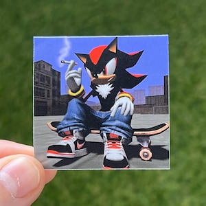 May include: Square sticker featuring a digital illustration of Shadow the Hedgehog, smoking a cigarette while sitting on a skateboard. The character is wearing blue jeans and sneakers. The background shows a cityscape.