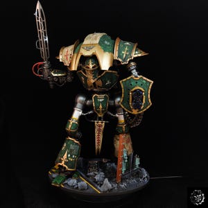 Pode incluir: Modelo detalhado de uma figura robótica verde e dourada, segurando uma grande espada com efeito de raio. A figura tem um escudo e está em pé sobre uma base com detritos. O modelo é pintado com detalhes intrincados e um acabamento metálico.