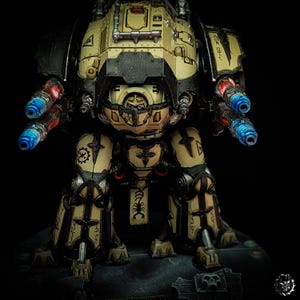 May include: A detailed model of a war machine in tan, black, and metallic colors. The model features multiple cannons with blue and red glowing effects. The design includes intricate details, symbols, and inscriptions, set against a dark background.
