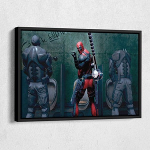 Pu&ograve; includere: Una stampa incorniciata di un'illustrazione umoristica che presenta Deadpool in un box del bagno, che punta a un'altra figura in un box, con il testo "The End" scritto sul muro.