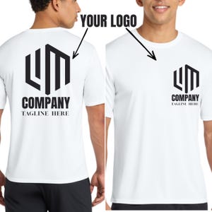 May include: A white short-sleeved t-shirt featuring a black hexagonal logo with the letters LM, the word COMPANY, and the text TAGLINE HERE. The design is displayed on the back and as a smaller chest print on the front of the garment.