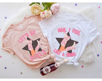 May include: Two pink and white t-shirts with a graphic of pink cowboy boots and a star. The pink shirt says "Let's Go Girls" and the white shirt says "Man, I Feel Like A Bride".