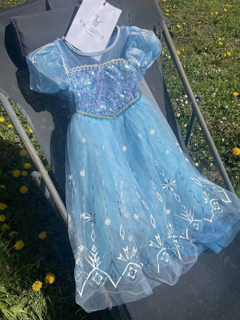 A magical Elsa princess dress with a glistening bodice, airy sleeves, and a tulle skirt, ideal for a young girl's dress-up collection