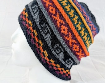 May include: A colorful knit beanie with a geometric pattern. The hat features bands of orange, yellow, green, purple, gray, and black. The beanie is displayed on a white mannequin head.