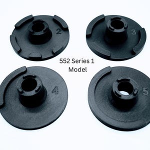 May include: Four black plastic circular components with central holes and raised edges. Each component is marked with a number from 2 to 5. The text "552 Series 1 Model" is also present.