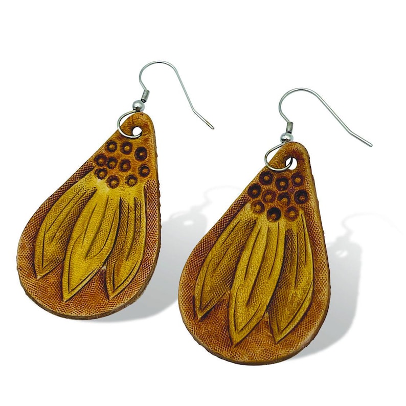May include: A pair of dangle earrings made of brown leather with a flower design. The earrings have a teardrop shape and are accented with a silver hook.