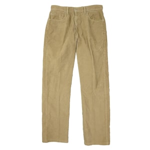 Puede incluir: Pantalones de pana color beige con un diseño clásico de cinco bolsillos. Los pantalones tienen un corte de pierna recta y cierre de botón y cremallera. La tela de pana tiene una textura acanalada. Los pantalones son de color neutro.