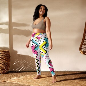 May include: High-waisted leggings with a vibrant 80s-inspired geometric pattern. The design features a white base with black polka dots, pink triangles, yellow zigzags, and teal lines. These leggings are a bold statement piece.