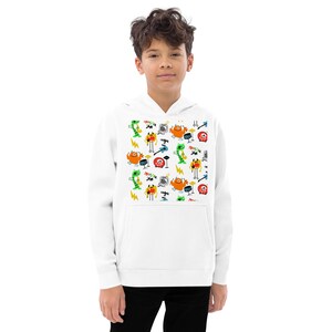 Op de afbeelding: Witte hoodie met een kleurrijk patroon van cartoonfiguren die muziek maken. De figuren zijn gekleed in verschillende kleuren en hebben verschillende gezichtsuitdrukkingen. De tekst "Rock On" wordt herhaald in het hele patroon.