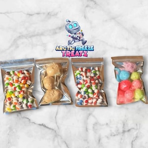 May include: Four clear plastic bags filled with colorful candies and treats. The bags are sealed with a brown top. The image includes a logo with a robot and the text "ARCTIC FREEZE TREATZ". The candies include colorful round candies, and other treats.