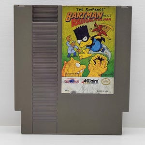 May include: A gray NES cartridge featuring the game "The Simpsons: Bartman Meets Radioactive Man." The label shows Bart Simpson as Bartman, Radioactive Man, and other characters in a colorful illustration. The cartridge is marked "Made in USA."