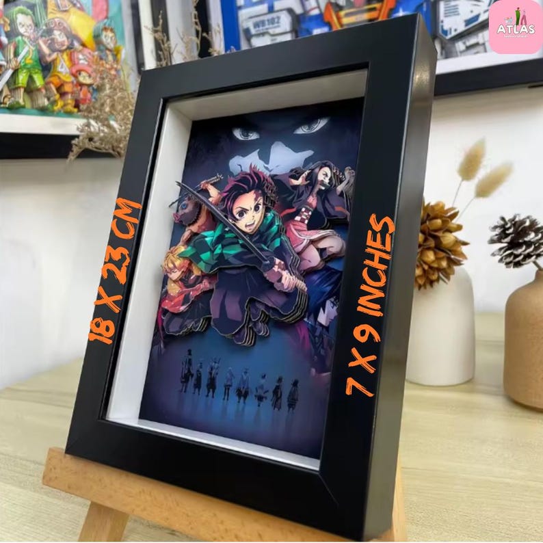 May include: A framed 3D artwork featuring characters from an anime series. The black frame holds a layered paper illustration with vibrant colors. The artwork measures 7 x 9 inches and 18 x 23 cm. The image is displayed on a small wooden easel.