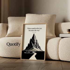 May include: A framed black and white print with a mountain and a winding road leading to the top. The quote "What stands in the way, becomes the way." is printed below the image.