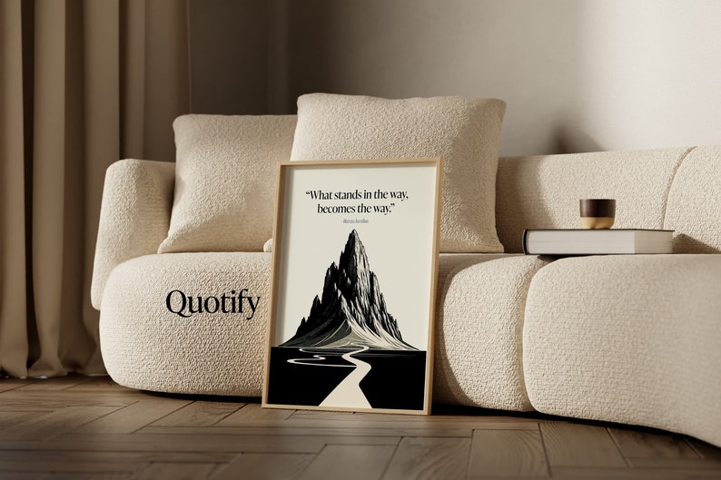 May include: A framed black and white print with a mountain and a winding road leading to the top. The quote "What stands in the way, becomes the way." is printed below the image.