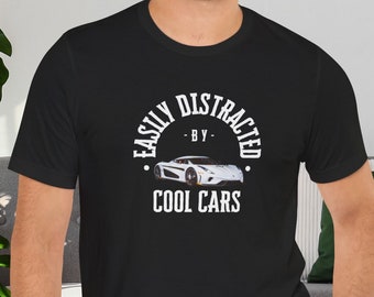 Puede incluir: Camiseta negra con un gráfico blanco que dice "Easily Distracted - By - Cool Cars" y una imagen blanca de un coche deportivo.