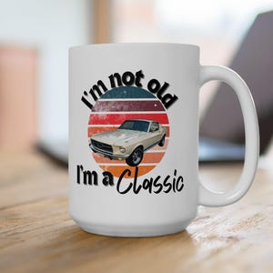 May include: White ceramic mug featuring a vintage-style graphic of a classic car and the text "I'm not old I'm a Classic".