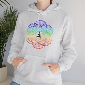May include: A gray hoodie with a colorful mandala design featuring a person in a yoga pose. The mandala is made up of seven colors, including red, orange, yellow, green, blue, indigo, and violet.