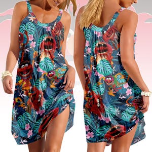 Könnte beinhalten: Ein ärmelloses Kleid mit einem lebendigen Aufdruck von Muppet-Charakteren und tropischem Laub in Blau-, Grün-, Rosa- und Rottönen. Das Kleid hat einen Rundhalsausschnitt und ein fließendes, knielanges Design.
