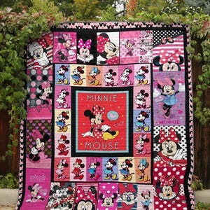 Könnte beinhalten: Eine rosafarbene und rote Bettdecke mit Minnie Mouse-Motiv. Die Bettdecke zeigt verschiedene Minnie Mouse-Bilder, darunter ihr Gesicht, ihre Silhouette und ihre charakteristischen Punkte. Die Bettdecke enthält auch den Text "Minnie Mouse".