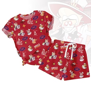 Könnte beinhalten: Rotes Pyjama-Set mit einem sich wiederholenden Muster aus Cartoon-Charakteren, Sternen und Text. Das Set besteht aus einem kurzärmeligen Oberteil und Shorts mit Kordelzug in der Taille. Text enthält "HAZBIN HOTEL", "SMILE MY DEAR!" und "IT'S A DEAL THEN?"