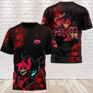 Könnte beinhalten: Schwarzes T-Shirt mit einem Cartoon-Charakter-Design mit roten und schwarzen Akzenten. Die Vorderseite des T-Shirts zeigt eine Charakterillustration mit einem rot-schwarzen Farbschema. Die Rückseite des Shirts hat ein ähnliches Design mit Text.