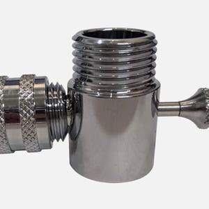 May include: A chrome-plated metal adapter with a threaded end and a lever handle. The adapter is designed to connect two different sized hoses or pipes.